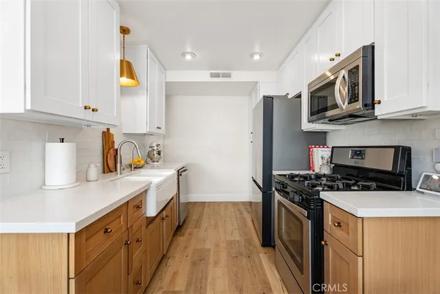 a kitchen with stainless steel appliances a stove a sink a microwave and cabinets