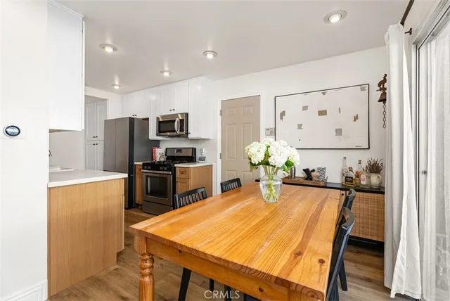 a kitchen with a table chairs refrigerator and microwave