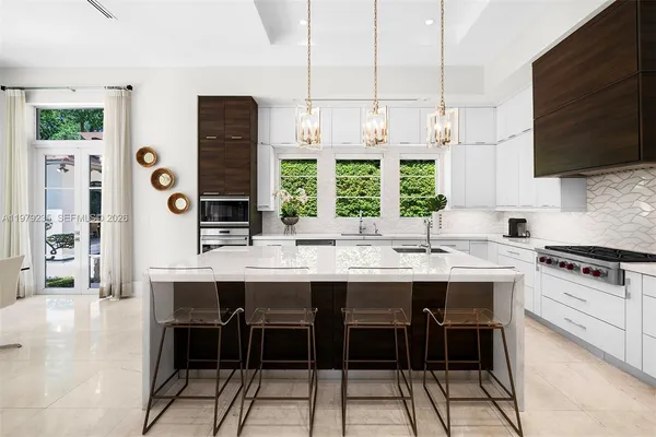 a kitchen with stainless steel appliances a stove a sink and a refrigerator
