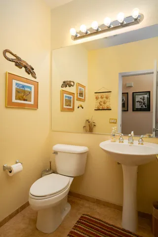 a bathroom with a toilet a sink and mirror