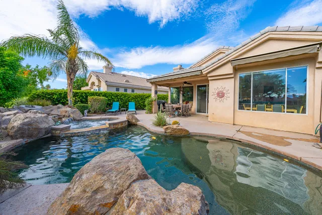 a view of a house with backyard patio and swimming pool