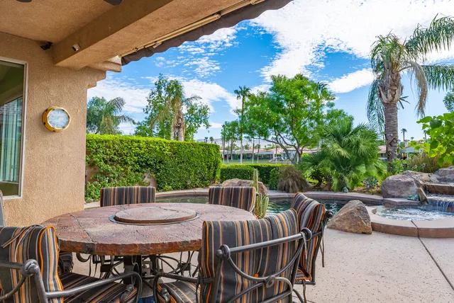 a view of a patio with table and chairs with wooden floor and plants