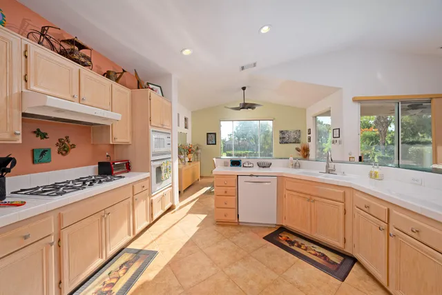 a kitchen with stainless steel appliances a sink a stove a refrigerator and cabinets