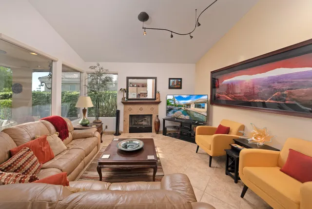 a living room with furniture a flat screen tv and a fireplace