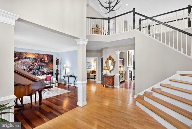 a dining room with wooden floor a chandelier a wooden table and chairs