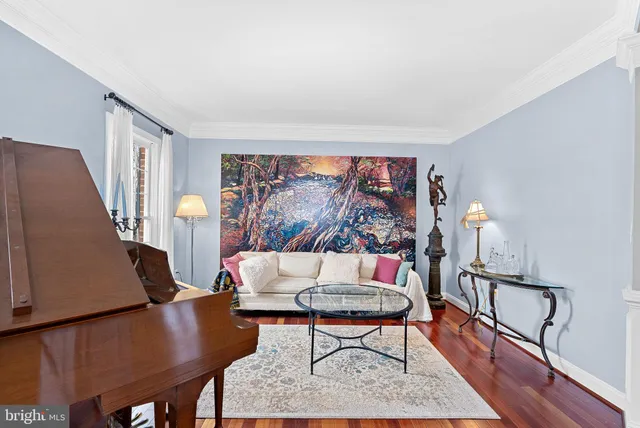 a bedroom with a bed large mirror and a flat tv screen on dresser