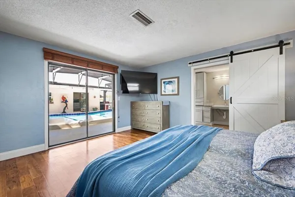 a bedroom with a bed lamp on desk and a window