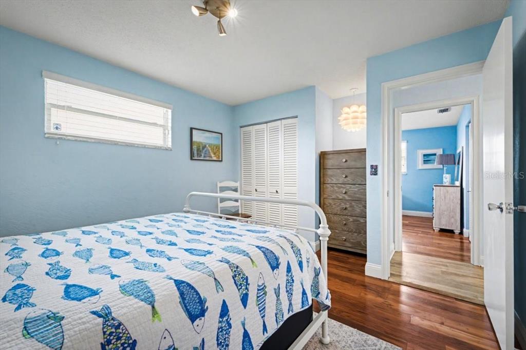 124 Anchor Drive Ponce Inlet, FL 32127 - Photo 28 of 77 a bedroom with a bed and a chandelier