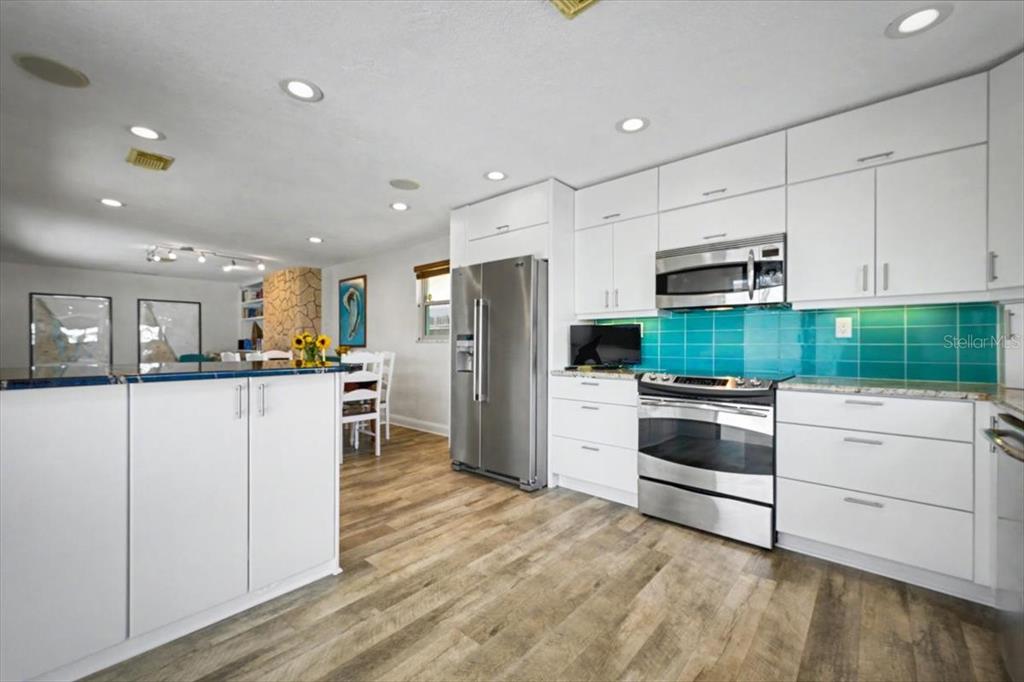 124 Anchor Drive Ponce Inlet, FL 32127 - Photo 46 of 77 a kitchen with white cabinets and stainless steel appliances