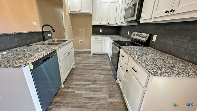 a kitchen with granite countertop a sink and a stove