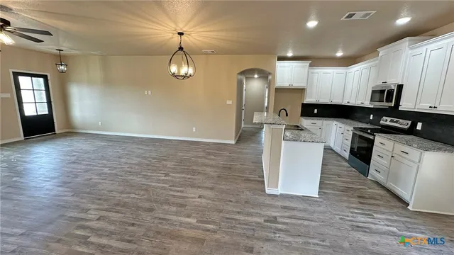 a kitchen with stainless steel appliances granite countertop a stove a sink and a refrigerator