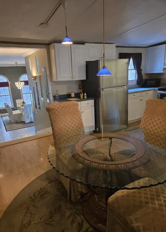 a living room with couches and kitchen view with wooden floor