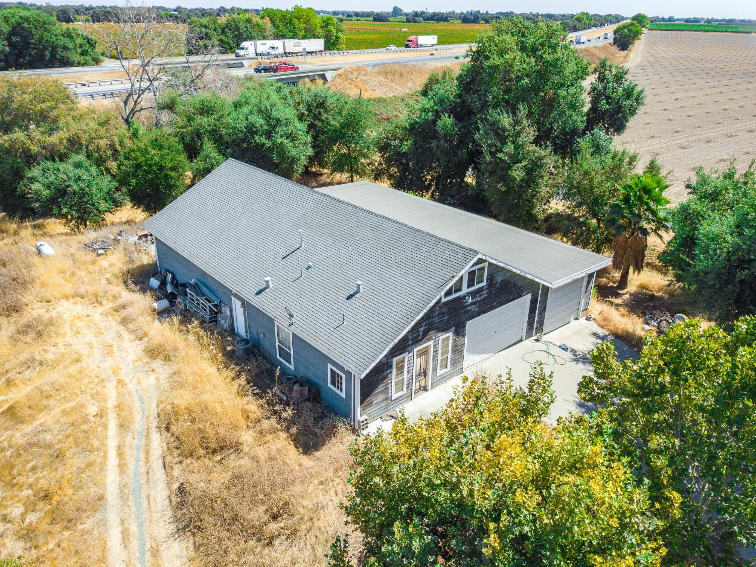 a view of a house with a yard and large trees