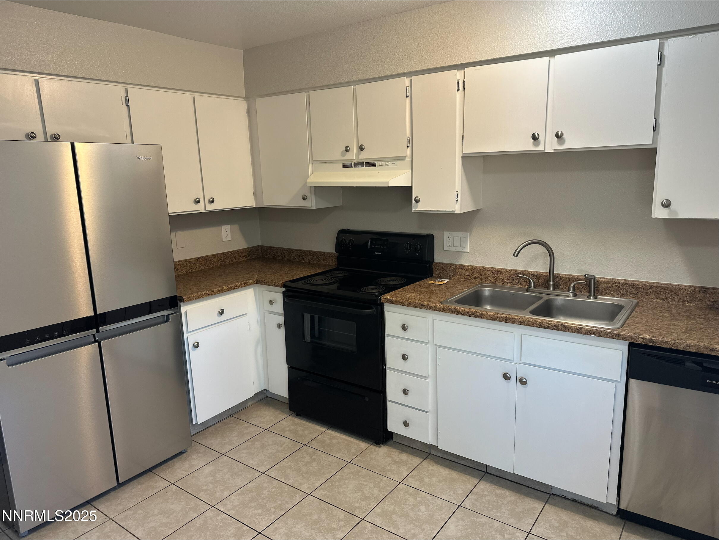 1424 East 9th Street, Unit 2 Reno, NV 89512 - Photo 7 of 20 a kitchen with granite countertop white cabinets and refrigerator