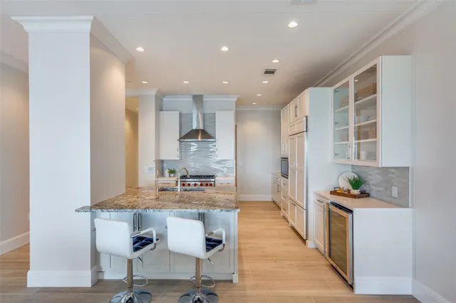 a kitchen with kitchen island granite countertop wooden cabinets and refrigerator