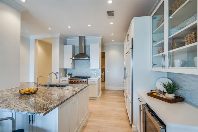 a kitchen with stainless steel appliances granite countertop a sink a stove and a refrigerator