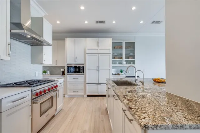 a kitchen with granite countertop a sink stove and refrigerator