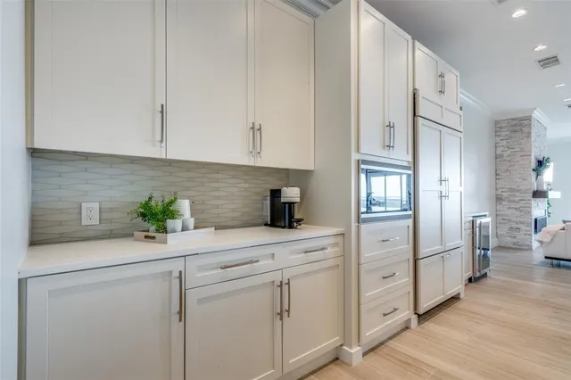a kitchen with white cabinets and appliances