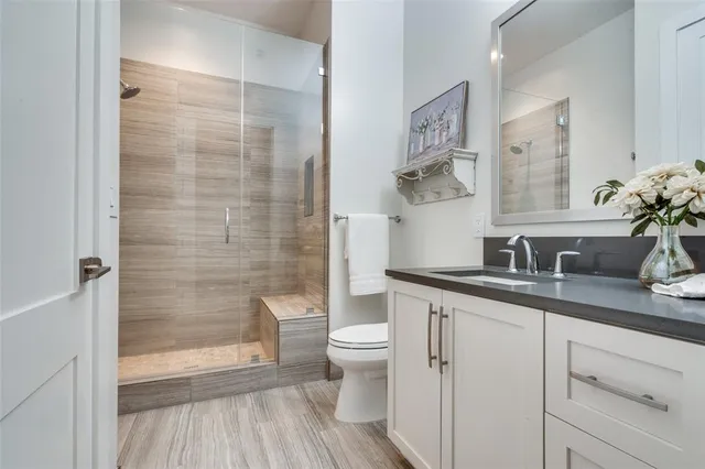 a bathroom with a granite countertop sink toilet and shower