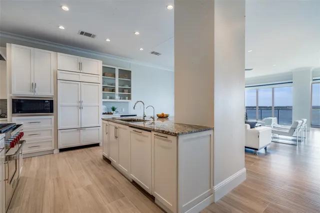 a kitchen with white cabinets and sink