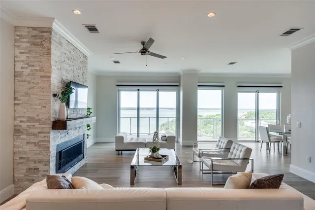 a living room with fireplace furniture and floor to ceiling windows