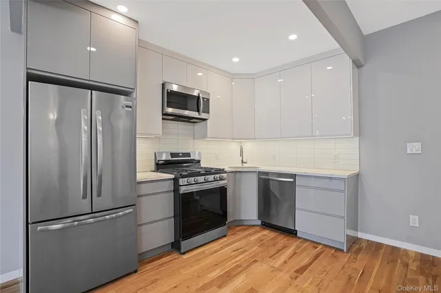 a kitchen with stainless steel appliances granite countertop a refrigerator stove and sink