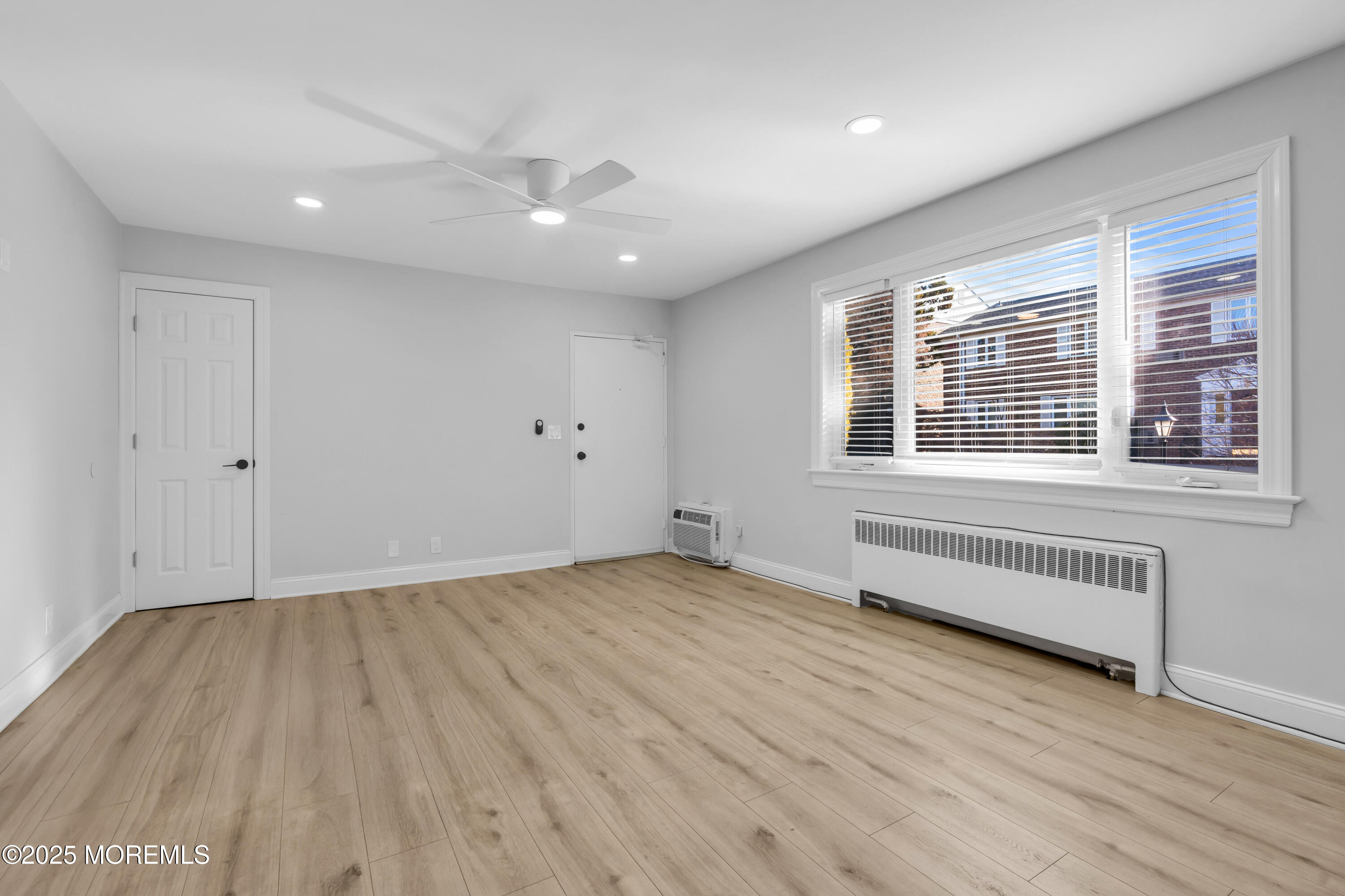 283 Spring Street, Unit 3A Red Bank, NJ 07701 - Photo 15 of 21 a view of an empty room with wooden floor and a window