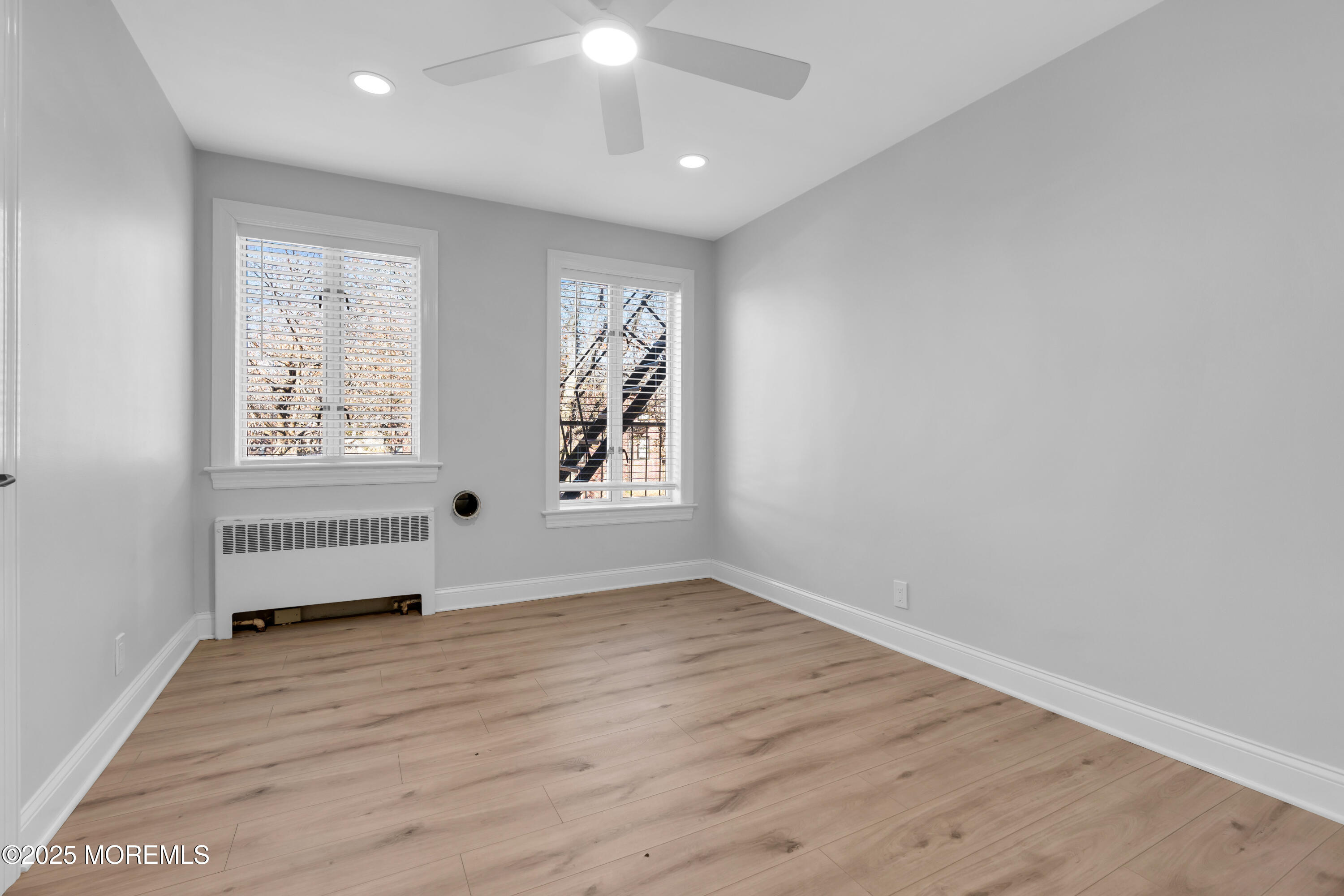 283 Spring Street, Unit 3A Red Bank, NJ 07701 - Photo 8 of 21 an empty room with wooden floor and windows