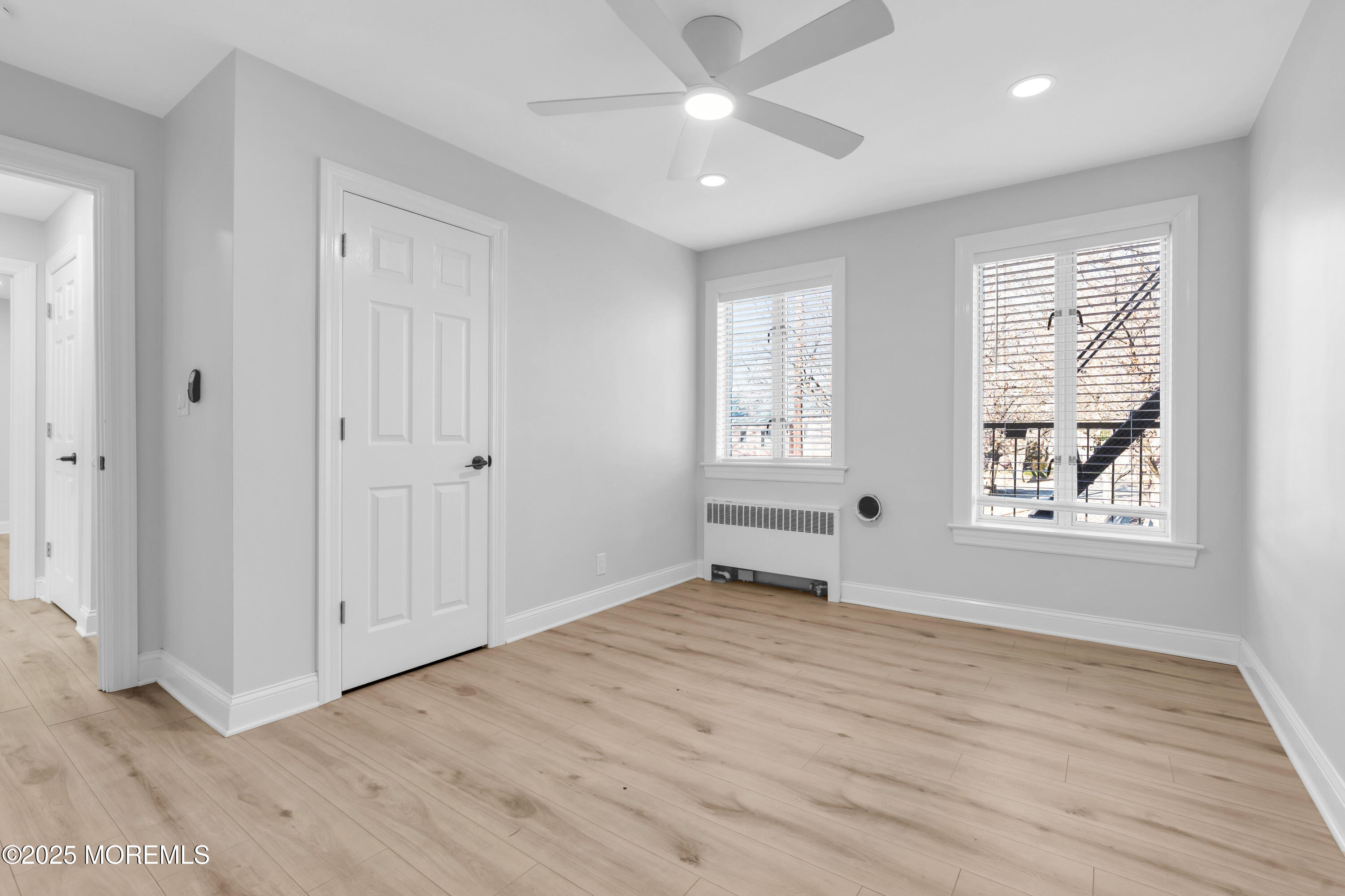 283 Spring Street, Unit 3A Red Bank, NJ 07701 - Photo 9 of 21 a view of an empty room with a window and wooden floor