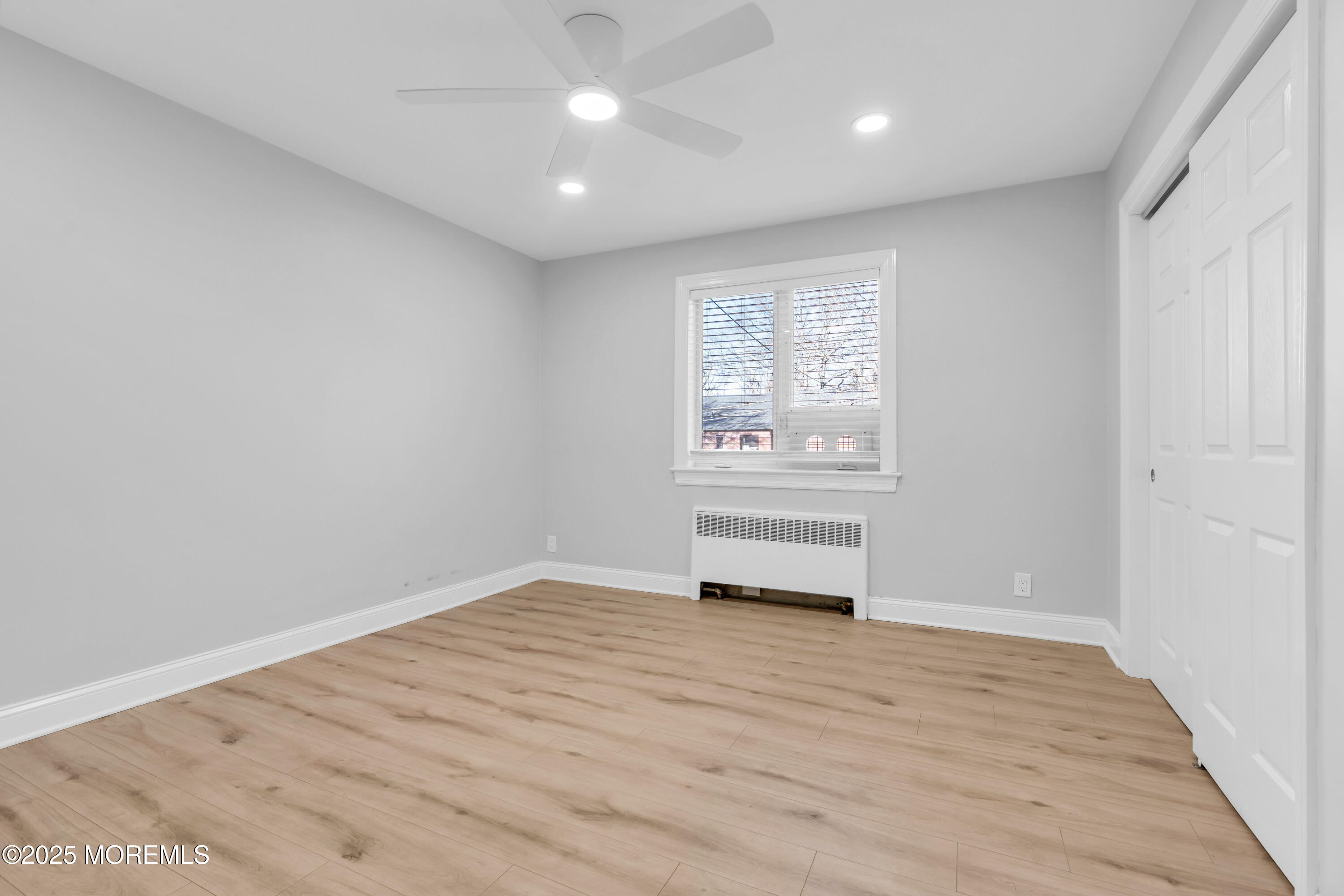 283 Spring Street, Unit 3A Red Bank, NJ 07701 - Photo 10 of 21 wooden floor in an empty room with a window