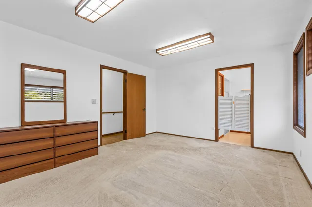 a view of an empty room with window and cabinet