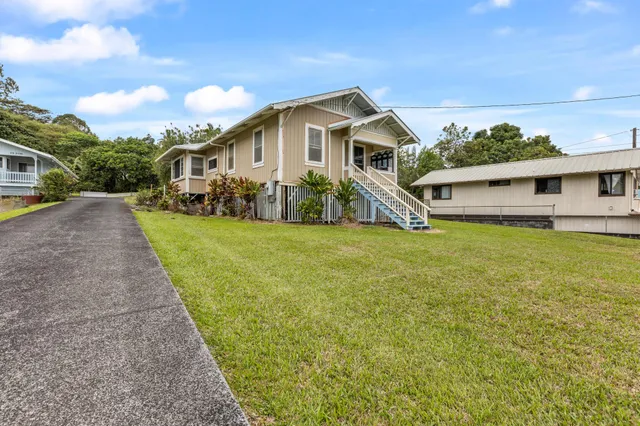 a front view of a house with yard and green space