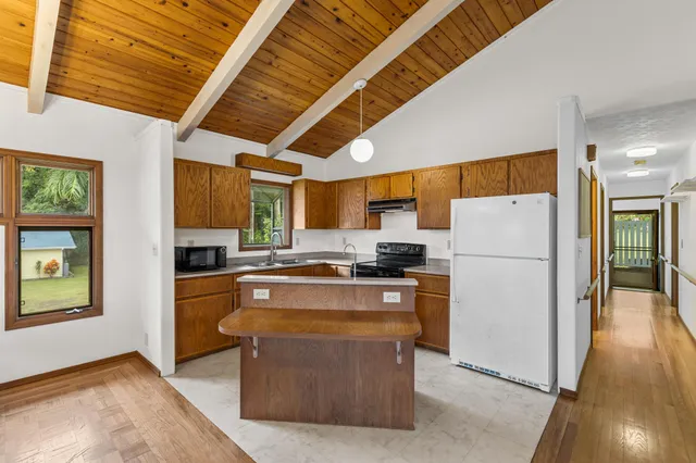 a kitchen with stainless steel appliances a refrigerator a stove a microwave and wooden floors