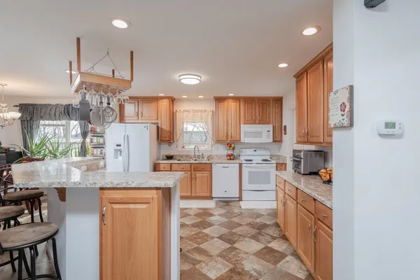 a kitchen with white cabinets and refrigerator