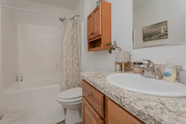 a bathroom with a granite countertop sink toilet and shower