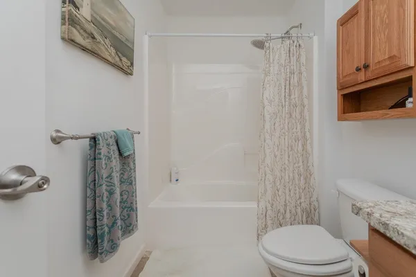 a bathroom with a shower a toilet and bathtub
