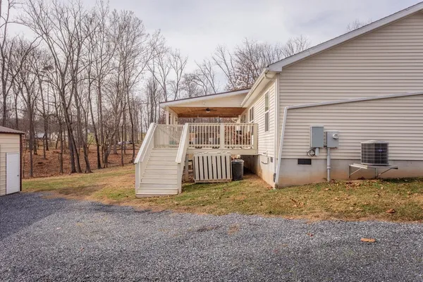 a view of a house with backyard and trees in the background