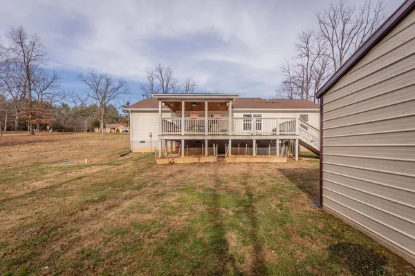 a view of a house with backyard and trees