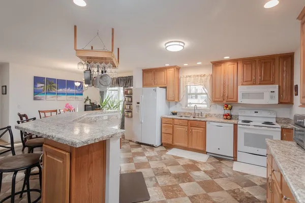 a kitchen with granite countertop cabinets a stove a dining table and chairs