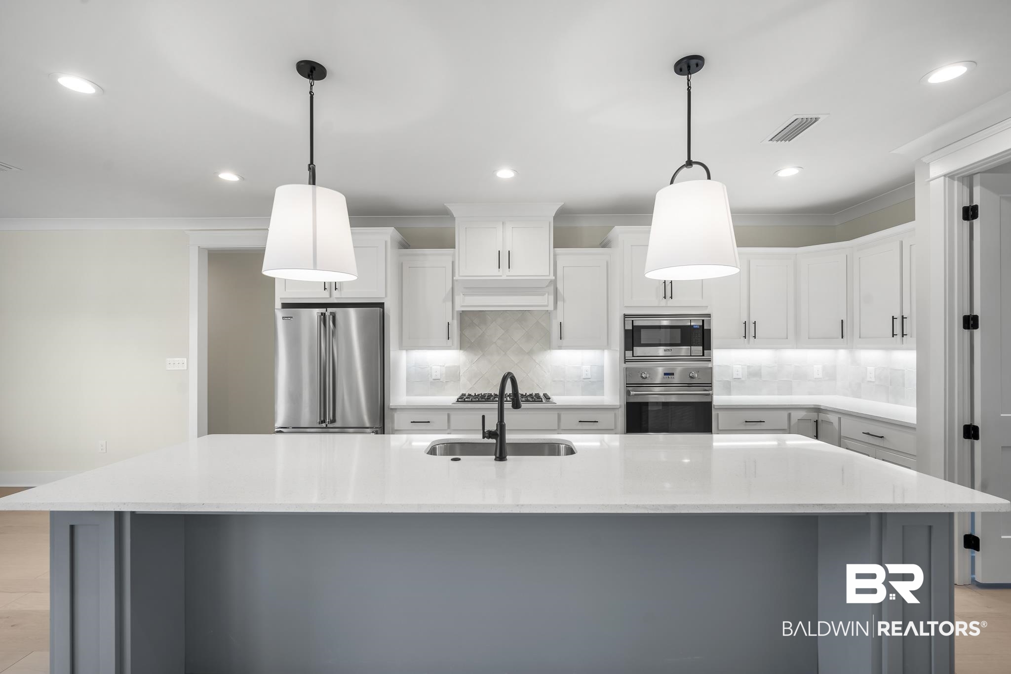 21826 Veranda Boulevard Fairhope, AL 36532 - Photo 9 of 42 Kitchen featuring white cabinetry, stainless steel appliances, decorative backsplash, ornamental molding, and pendant lighting