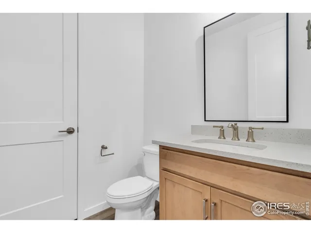 a bathroom with a toilet sink vanity and mirror