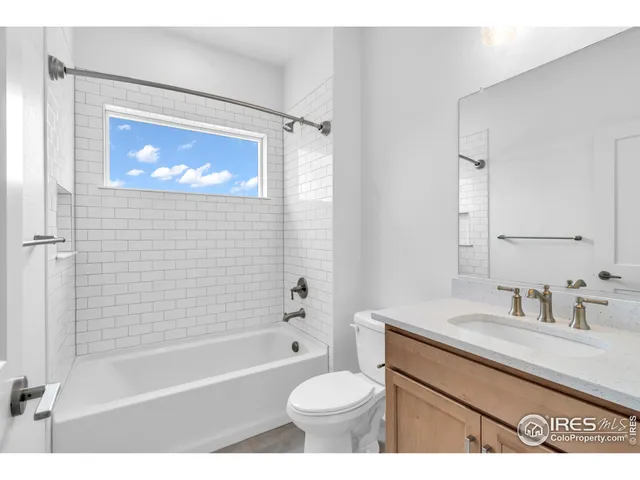 a bathroom with a sink a toilet a mirror a bathtub and shower