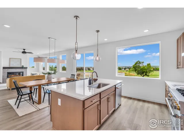 a kitchen with stainless steel appliances granite countertop a sink a stove and a wooden floors