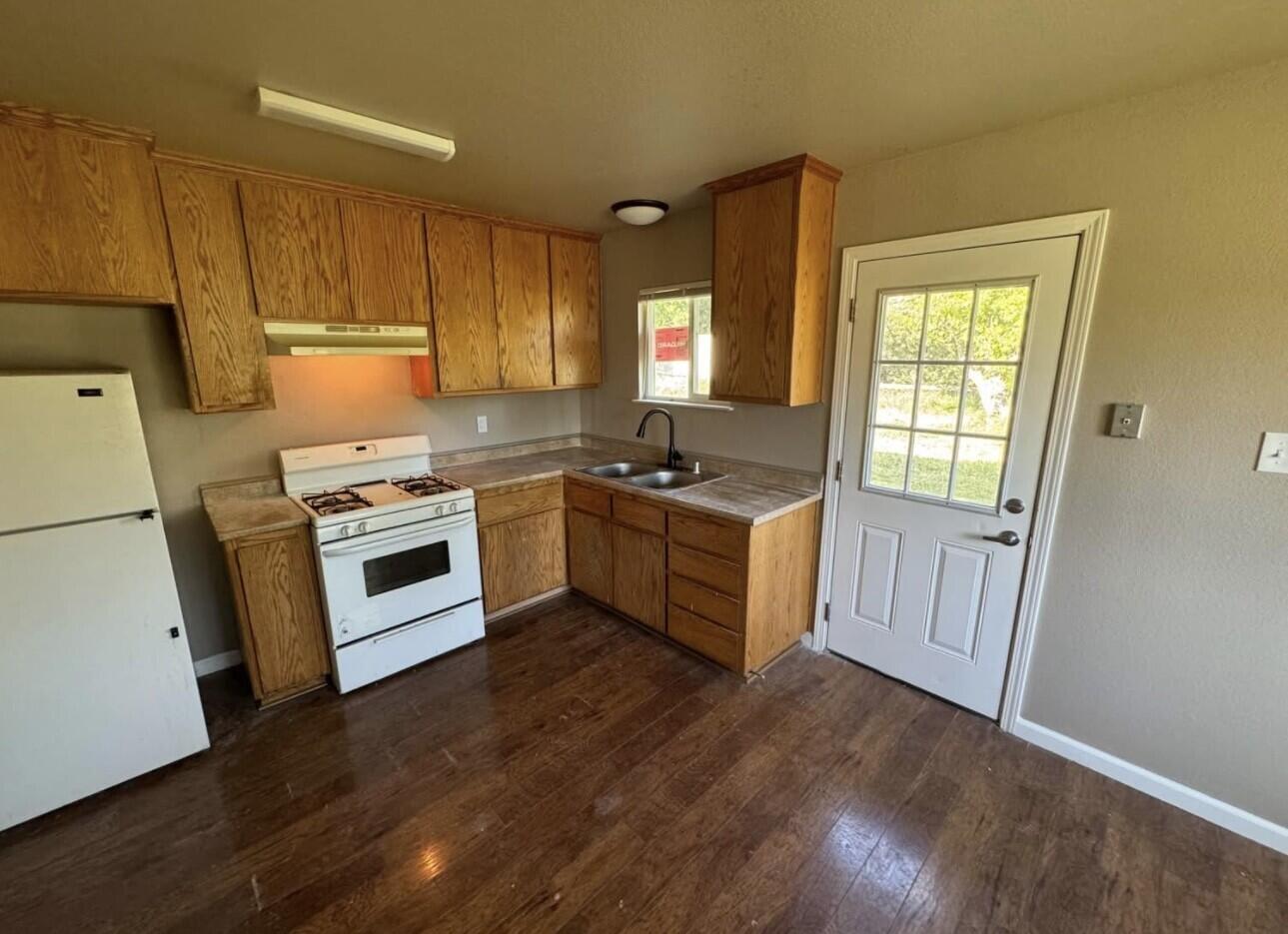 566 Roundup Avenue Red Bluff, CA 96080 - Photo 15 of 16 a kitchen with sink a stove a refrigerator and cabinets