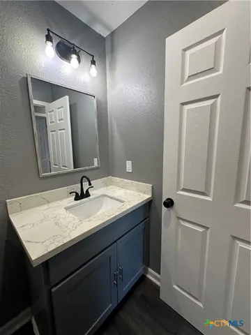 a bathroom with a granite countertop sink and a mirror