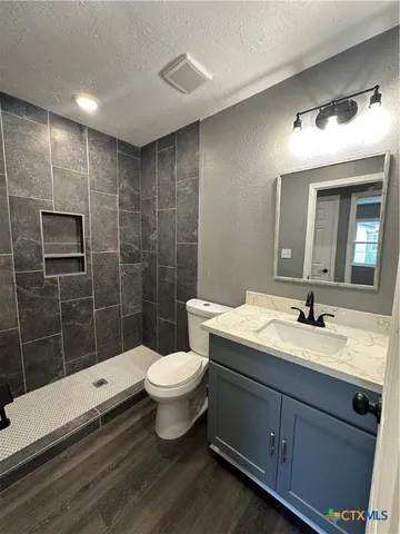 a bathroom with a sink toilet a mirror and shower