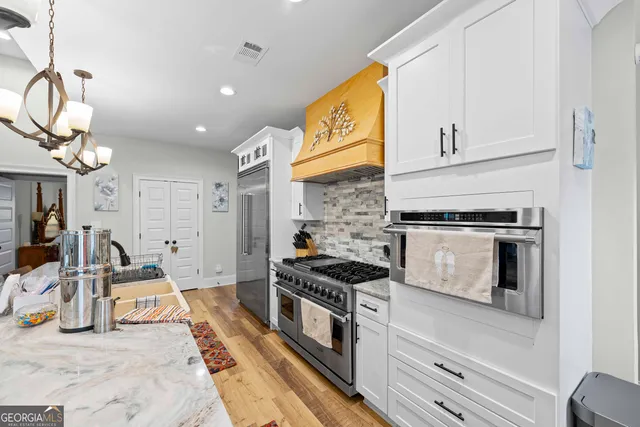 a kitchen with stainless steel appliances granite countertop a stove and a sink