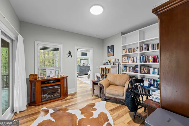 a living room with furniture a bookshelf and a window