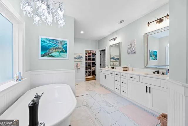 a spacious bathroom with double vanity sink a two mirror a window and a bathtub