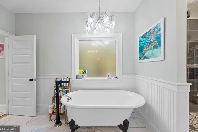 a bedroom with a large bed and a flat tv screen